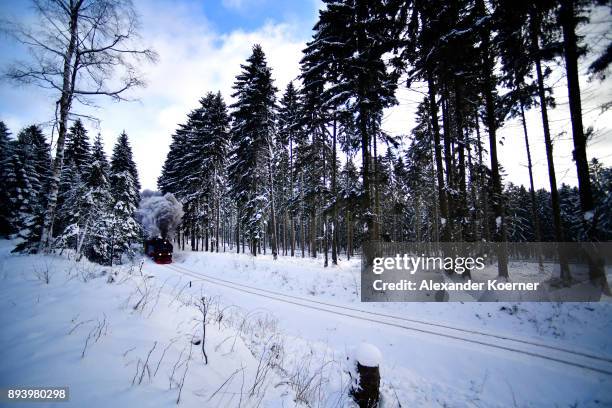 Steam powered locomotive of the Harz Narrow Gauge Railways travels through snow towards the station Brocken on December 16, 2017 in Wernigerode,...