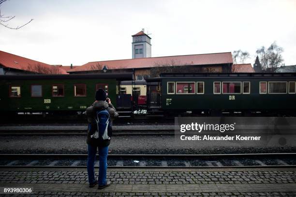 Visitor photographs a steam powered locomotive of the Harz Narrow Gauge Railways while leaving the station on December 16, 2017 in Wernigerode,...