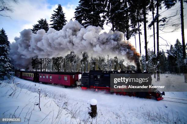 Steam powered locomotive of the Harz Narrow Gauge Railways travels through snow towards the station Brocken on December 16, 2017 in Wernigerode,...