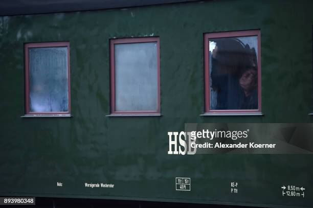Visitor cleans a window of a steam powered locomotive of the Harz Narrow Gauge Railways while to leaving the station on December 16, 2017 in...