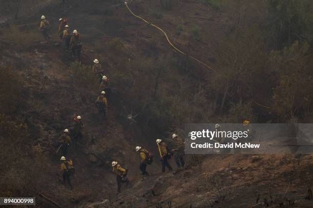 Hot Shot crew marches through a canyon between homes to fight the Thomas Fire on December 16, 2017 in Montecito, California. The National Weather...