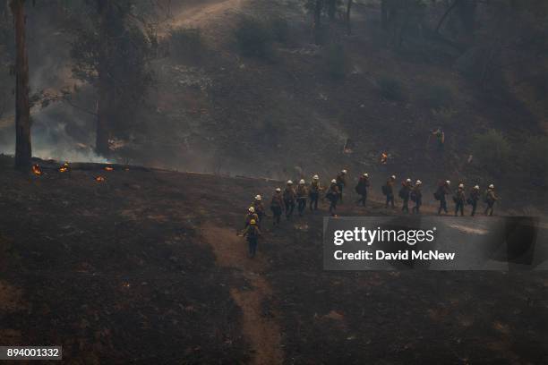 Hot Shot crew marches through a canyon between homes to fight the Thomas Fire on December 16, 2017 in Montecito, California. The National Weather...