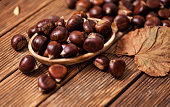 Ripe chestnuts in a frying pan on old wooden table close up with copy space. Roasted Chestnuts for Christmas'n