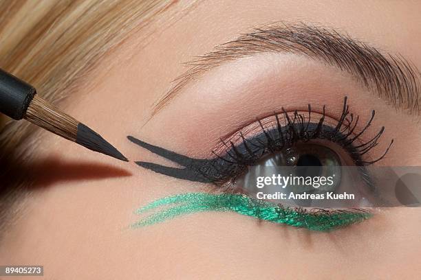 young woman applying eye make up, close up. - eyeliner stock pictures, royalty-free photos & images