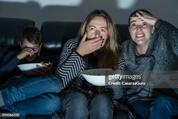 famiglia seduta sul divano e guardando la tv di notte - horror foto e immagini stock