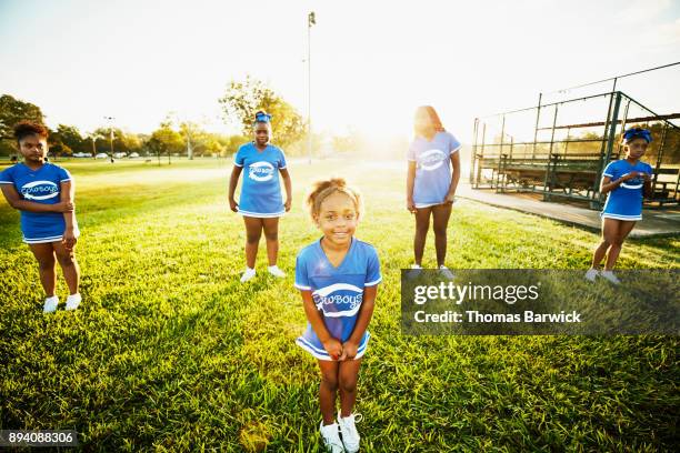 smiling young cheerleader lined up with teammate for early morning practice in park - black cheerleaders - fotografias e filmes do acervo