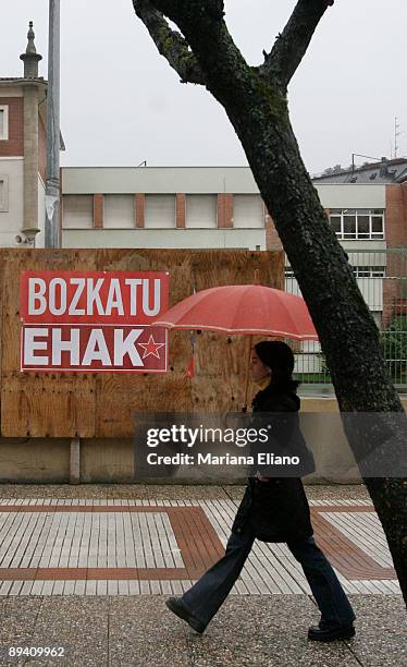 Woman walks by a political banner of the pro independence Communist Party of the Basque Lands in Llodio, northern Spain, Sunday, April.17, 2005.