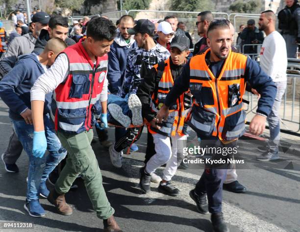 Men transport a person injured during the Palestinian demonstrations in Jerusalem on Dec. 15, 2017. The protests were in response to U.S. President...
