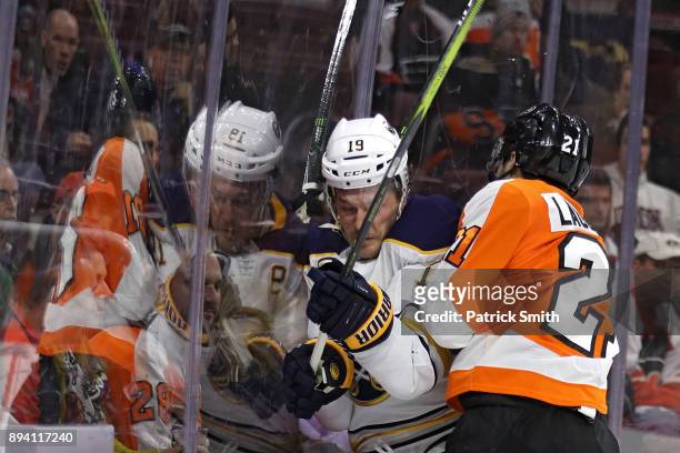 Jake McCabe of the Buffalo Sabres is checked by Scott Laughton of the Philadelphia Flyers during the second period at Wells Fargo Center on December...