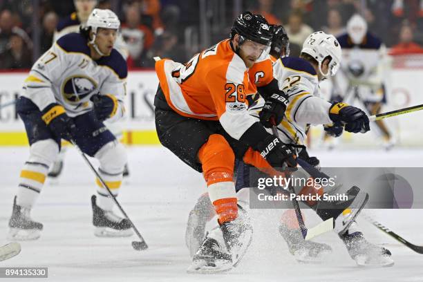 Claude Giroux of the Philadelphia Flyers is checked by Johan Larsson of the Buffalo Sabres during the third period at Wells Fargo Center on December...