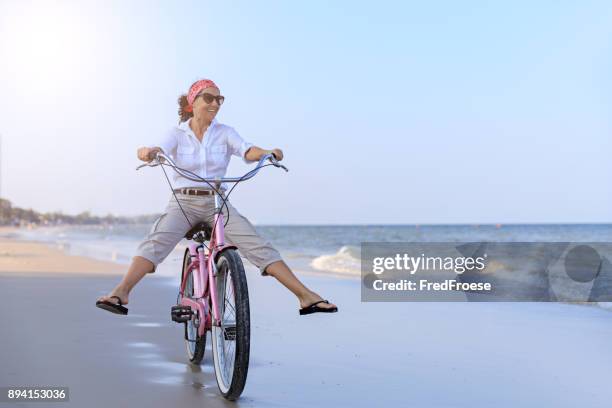 gelukkige vrouw rijden fiets op strand - bike beach stockfoto's en -beelden