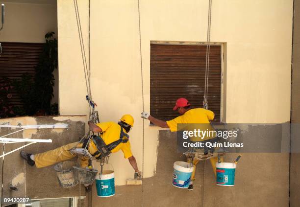 June, 2006. Madrid . Workers painting the inside of a yard house got out through the flat roof. With these works is avoided to assembling a...
