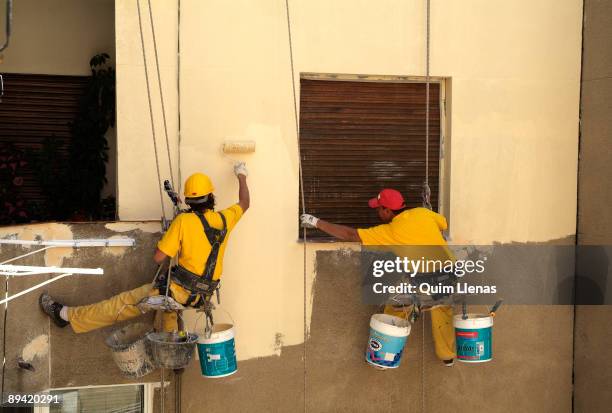 June, 2006. Madrid . Workers painting the inside of a yard house got out through the flat roof. With these works is avoided to assembling a...