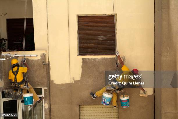 June, 2006. Madrid . Workers painting the inside of a yard house got out through the flat roof. With these works is avoided to assembling a...