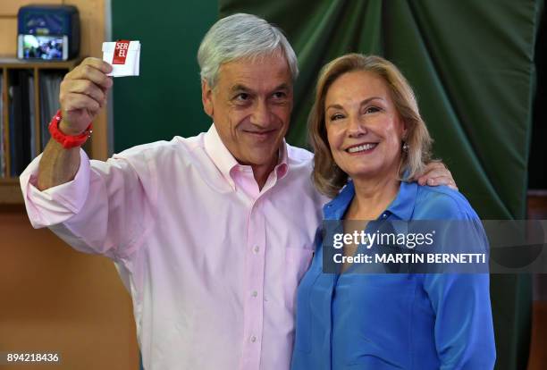 Chile's presidential candidate Sebastian Pinera shows his vote, next to his wife Cecilia Morel, during the presidential run-off election in Santiago,...