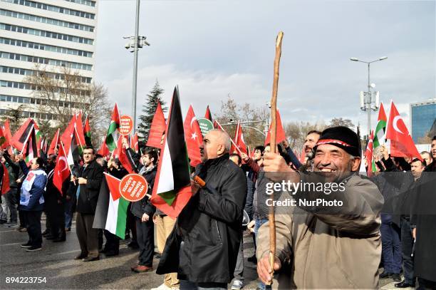 Man holds up a wooden stick as pro-Palestinian protesters take part in a rally against U.S. President Donald Trump's recognition the city of...