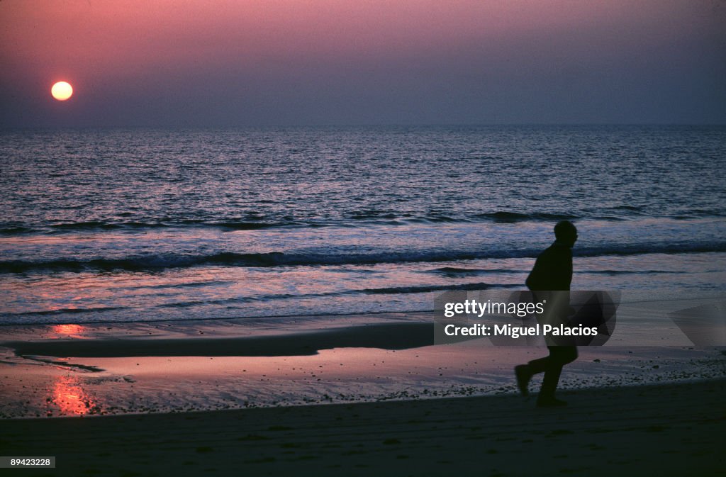 Sunset in a beach. A man running.