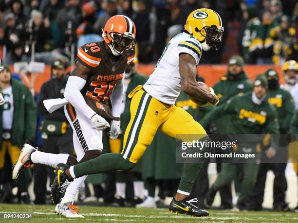 Wide receiver Davante Adams of the Green Bay Packers carries the ball downfield for the game winning touchdown as he is pursued by cornerback Jason...