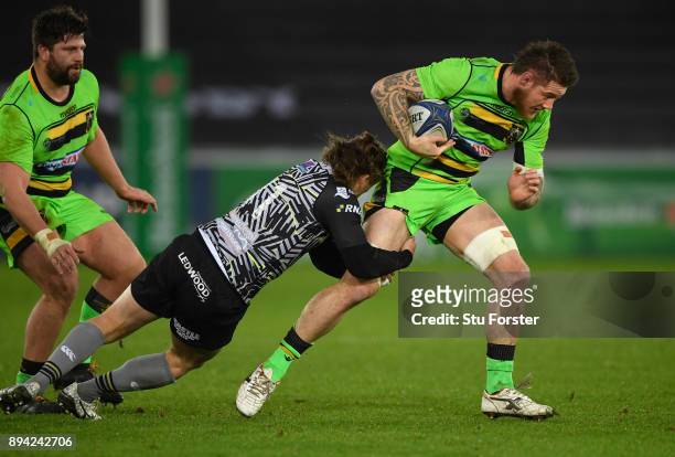 Ospreys wing Jeff Hassler puts in a tackle on Saints number 8 Teimana Harrison during the European Rugby Champions Cup match between Ospreys and...