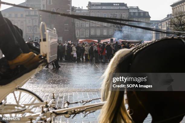 Tourist horse carriage passes next to the 21st Edition of the Biggest Christmas table in Europe at the Main Square in Krakow. The so called Christmas...