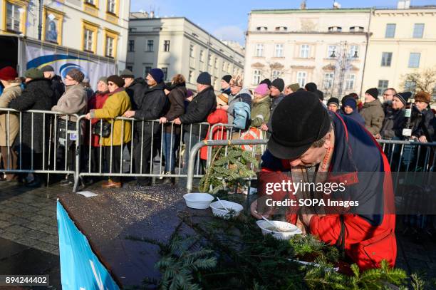 An attendent eats a warm meal as he take part in the 21st Edition of the Biggest Christmas table in Europe at the Main Square in Krakow. The so...