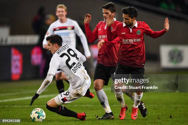 Kai Havertz of Bayer Leverkusen falls next to Julian Korb of Hannover 96 and Edgar Prib of Hannover 96 during the Bundesliga match between Hannover...