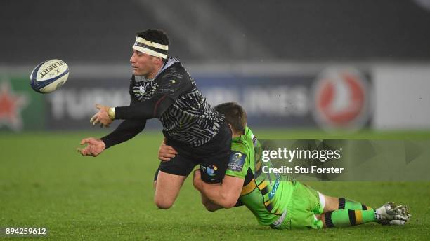 Ospreys centre Kieron Fonotia offloads despitre the attentions of Piers Francis during the European Rugby Champions Cup match between Ospreys and...