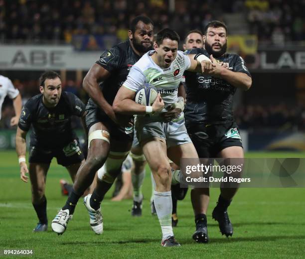 Sean Maitland of Saracens holds off Peceli Yato and Rabah Slimani during the European Rugby Champions Cup match between ASM Clermont Auvergne and...