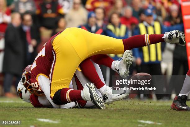 Quarterback Blaine Gabbert of the Arizona Cardinals is sacked by offensive tackle Kevin Bowen of the Washington Redskins in the first quarter against...