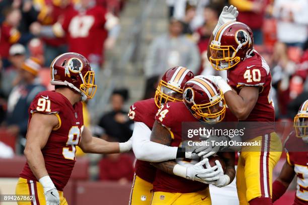 Outside Linebacker Preston Smith, linebacker Josh Harvey-Clemons and outside linebacker Ryan Kerrigan of the Washington Redskins celebrate after...