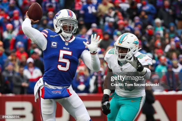 Tyrod Taylor of the Buffalo Bills throws the ball as Charles Harris of the Miami Dolphins attempts to defend him during the first quarter on December...