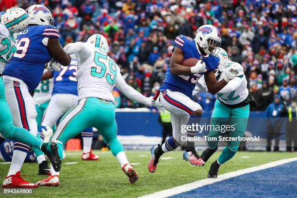 LeSean McCoy of the Buffalo Bills scores a touchdown as T.J. McDonald of the Miami Dolphins attempts to tackle him during the first quarter on...