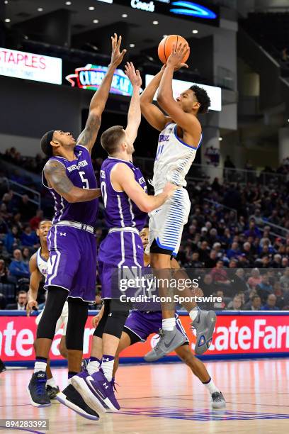 DePaul Blue Demons guard Eli Cain shoots over Northwestern Wildcats guard Bryant McIntosh and Northwestern Wildcats center Dererk Pardon during the...