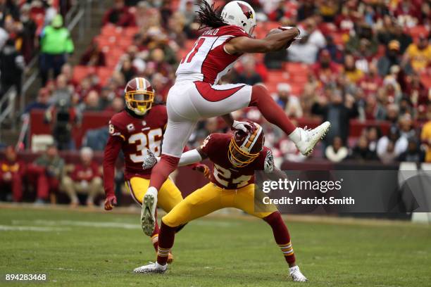 Wide Receiver Larry Fitzgerald of the Arizona Cardinals leaps over cornerback Josh Norman of the Washington Redskins in the first quarter at FedEx...