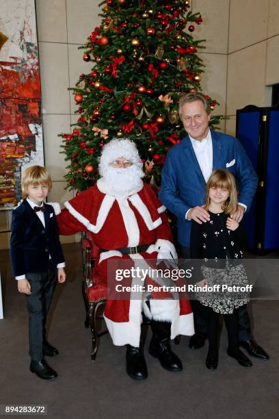 Andrea Canino and his children pose with "Santa Claus - Le Pere Noel" in front of a Christmas Tree during the 32th "Reve d'Enfants" : Charity Gala at...