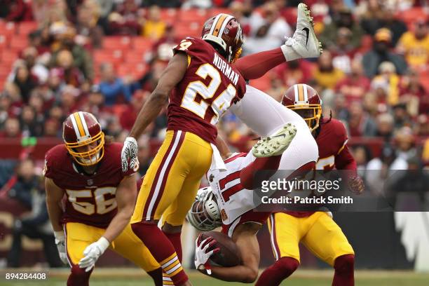 Wide receiver Larry Fitzgerald of the Arizona Cardinals is tackled by cornerback Josh Norman of the Washington Redskins during the first quarter at...