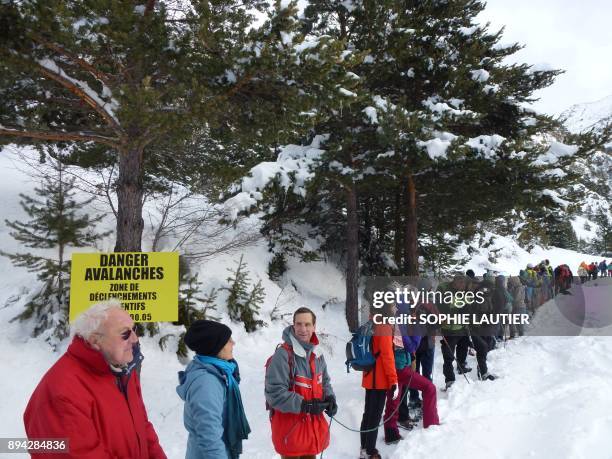 Mountain professionals stand linked together with ropes, as they take part in a rally to warn of the dangers to migrants in crossing passes in the...