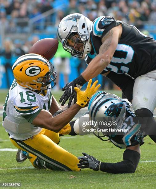 Kurt Coleman and Kevon Seymour of the Carolina Panthers break up a pass intended for Randall Cobb of the Green Bay Packers during their game at Bank...