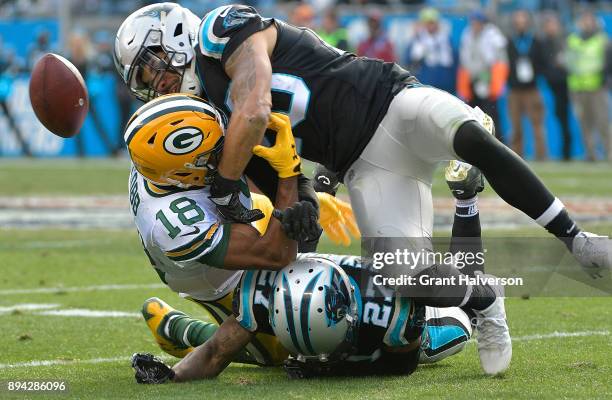 Kurt Coleman and Kevon Seymour of the Carolina Panthers break up a pass intended for Randall Cobb of the Green Bay Packers during their game at Bank...