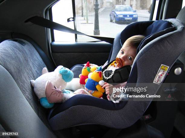 Toddler sitting in car seat.