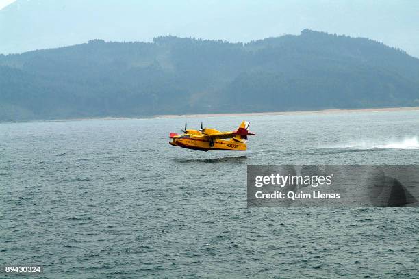 Asturias . Firefighting airplane charging water in the surrounding area of Lastres.