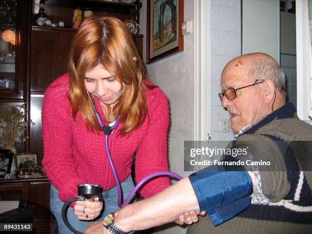 Family doctor taking the blood pressurein a home visit.