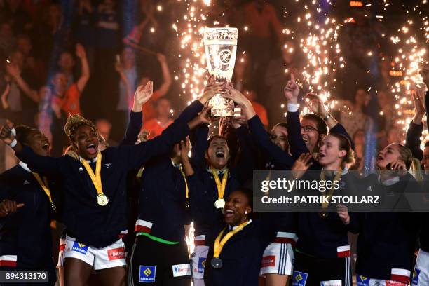 French team's captain Siraba Dembele holds the trophy next to her teammates after they won the IHF Womens World Championship handball final match...