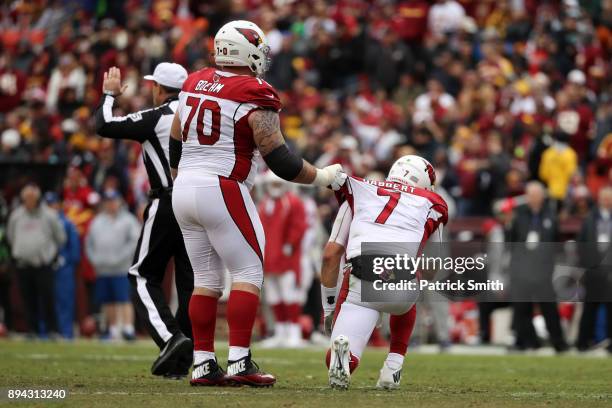 Offensive Guard Evan Boehm helps quarterback Blaine Gabbert of the Arizona Cardinals up after a play in the second quarter against the Washington...