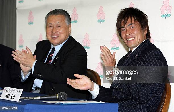 Japan Rugby Union President and former Prime Minister Yoshiro Mori and Kobelco Steelers player Daisuke Ohata clap hands as IRB decide Japan will host...