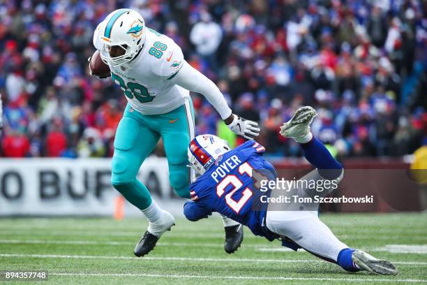 Julius Thomas of the Miami Dolphins runs the ball as Jordan Poyer of the Buffalo Bills attempts to tackle him during the third quarter on December...