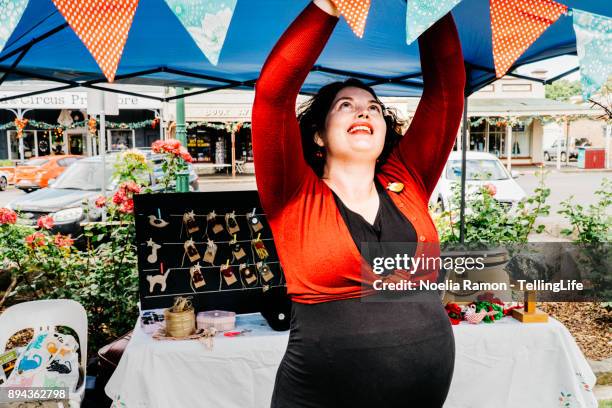 christmas markets: woman putting up decoration - christmas market australia stock pictures, royalty-free photos & images