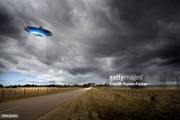 ufo on country road - flying saucer stock pictures, royalty-free photos & images