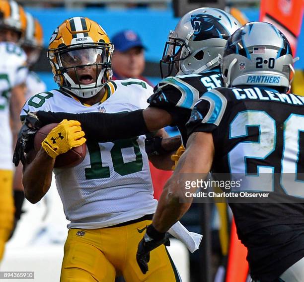 Carolina Panthers cornerback Kevon Seymour, center, forces Green Bay Packers wide receiver Randall Cobb to lose control of the ball during second...
