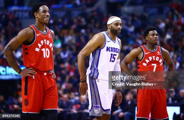 Vince Carter of the Sacramento Kings, DeMar DeRozan and Kyle Lowry of the Toronto Raptors watch a free throw during the first half of an NBA game at...